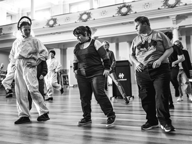 Isabella Stone - Three dancers captured in a black and white photograph line dancing at the opening of the 2021 ATC exhibition