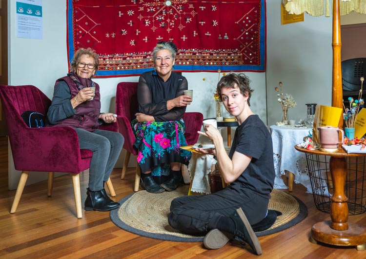 Three ladies sitting together sharing a cup of tea
