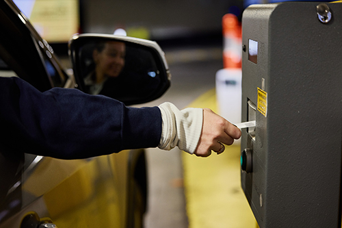 A driver getting a parking voucher while entering a car park