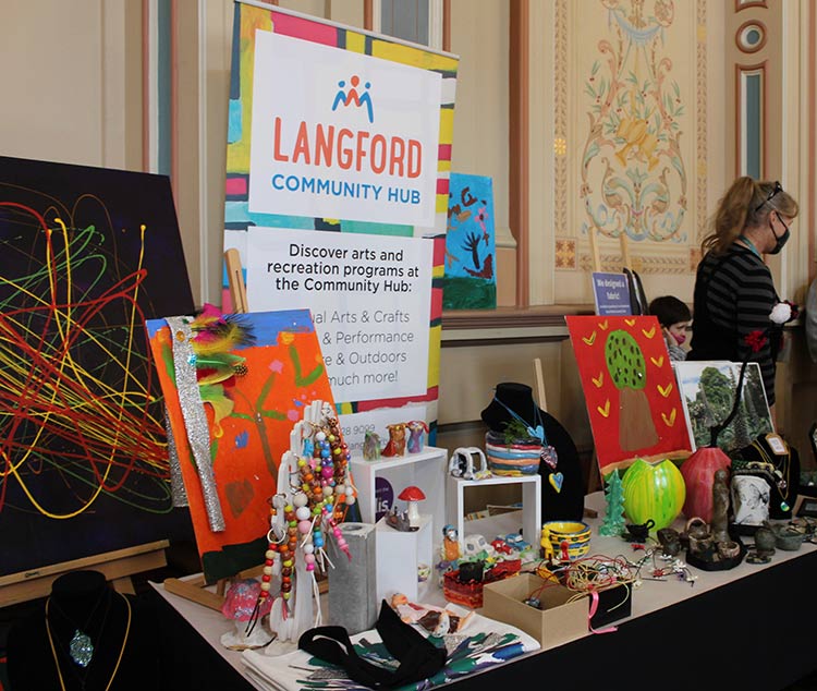 Full marketplace stall showing art work, jewellery and ceramics.