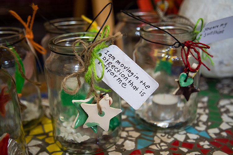 Glass jars with ceramic stars on the side. Gift tags read: 'I am moving in the direction that is best for me'.