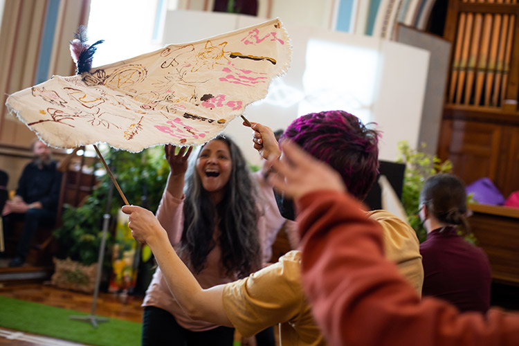 Artists dancing with moth puppets.