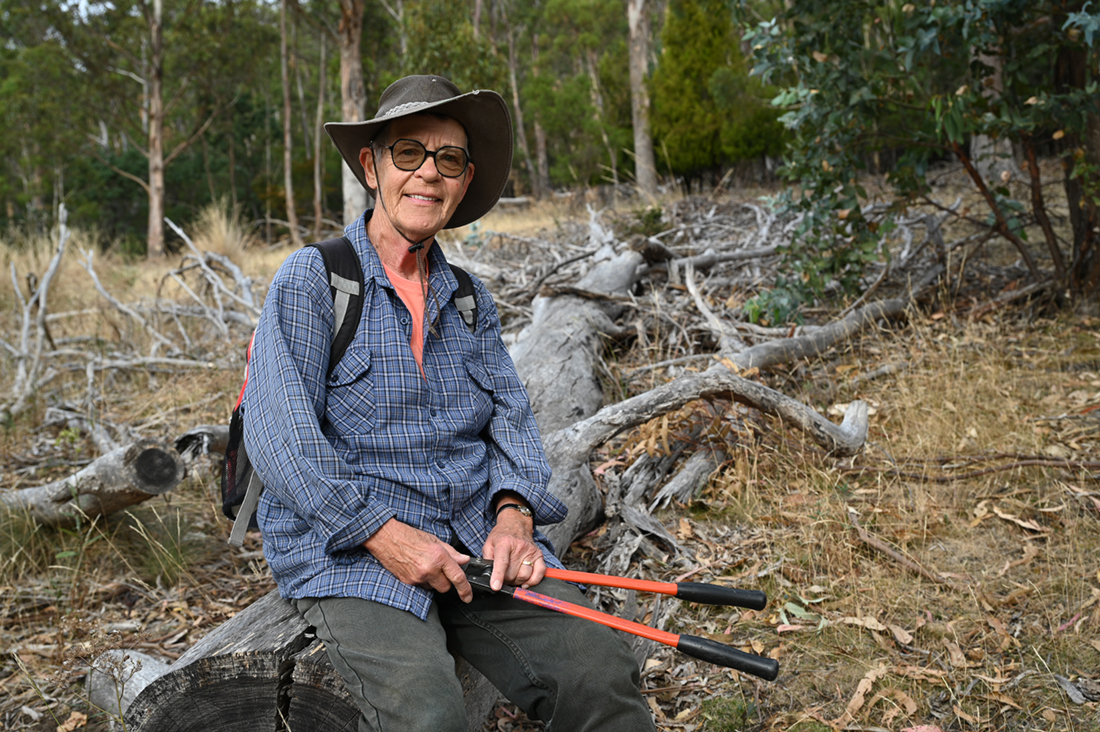 Astrid Wright in her element, surrounded by a field of dead gorse and native grasslands bouncing back to health