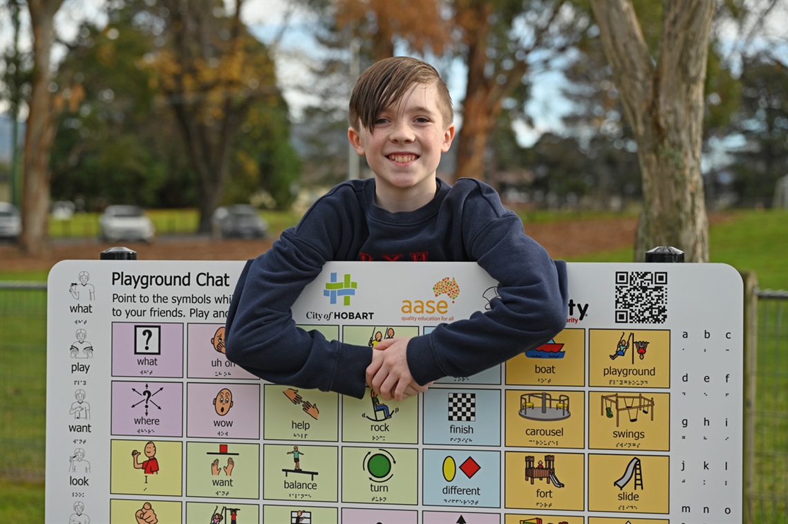 Noah Dobson with a communicator board at Long Beach Reserve playground