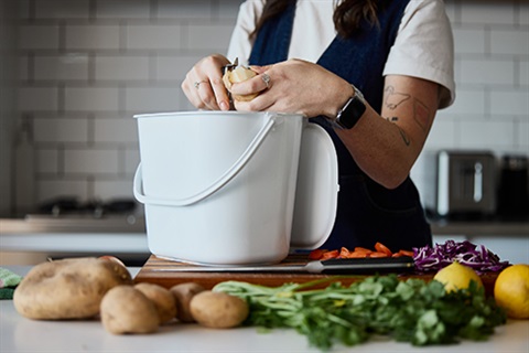 Placing food scraps into a FOGO kitchen caddy